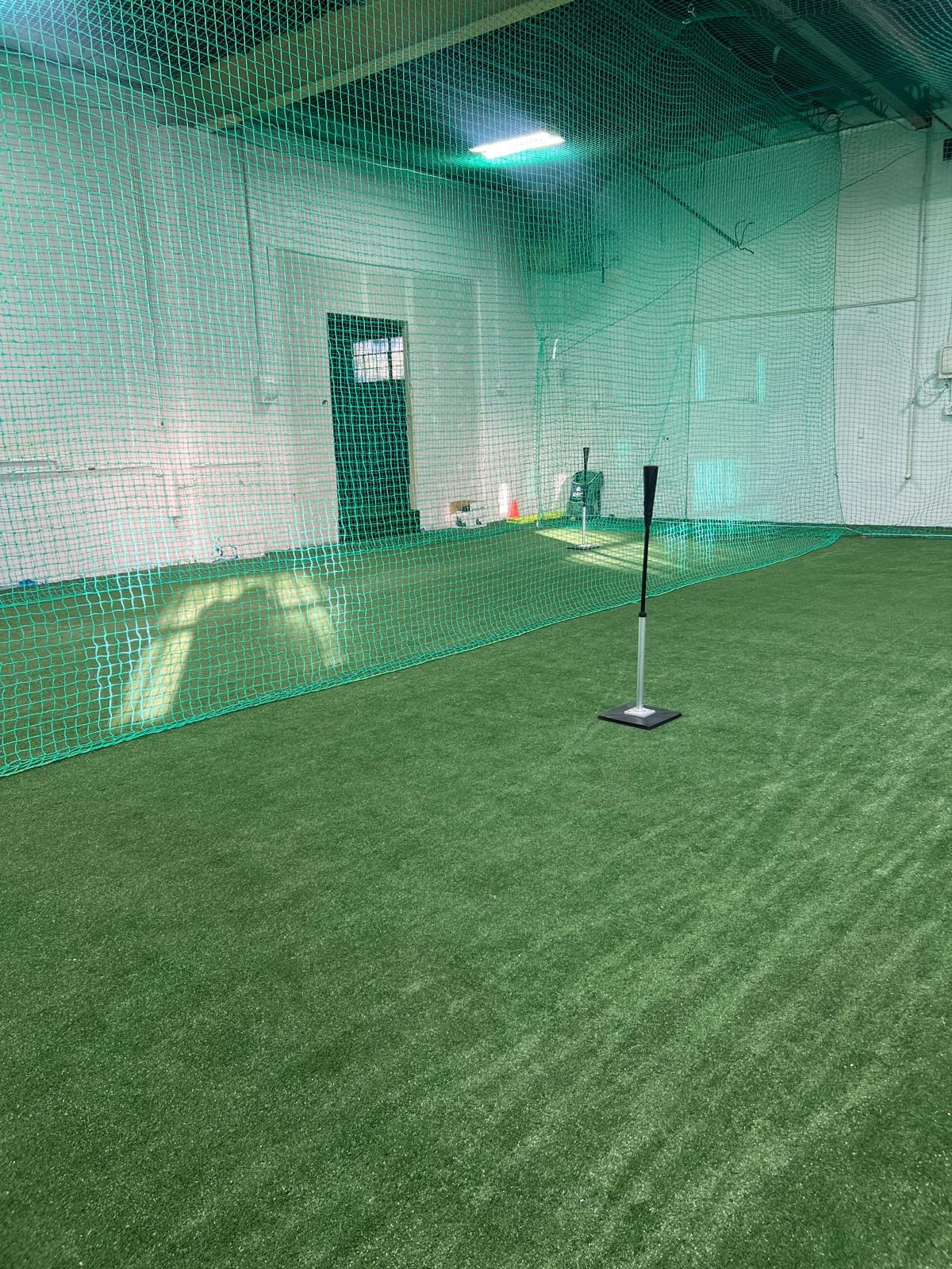 Batting tee and practice equipment in an indoor cage